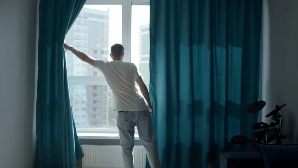 a-man-in-a-dark-apartment-with-curtains-media-an-2026-01-06-10-00-47-utc